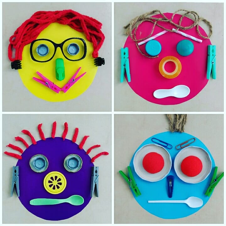 Four colorful and playful face collages made by kids using recycled materials, including yarn for hair, bottle caps for eyes, clothespins, plastic spoons, and other household items, all arranged on brightly colored circular paper bases.
